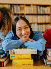 High school students at a communal desk behind stacks of books